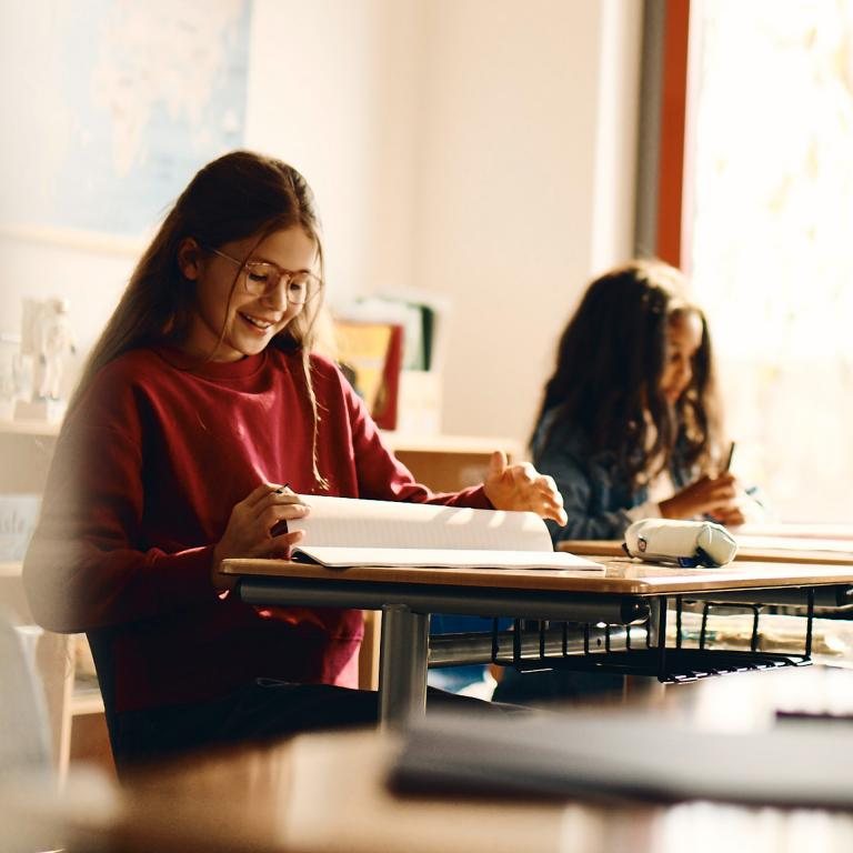 Ragazza con occhiali da vista che studia a scuola